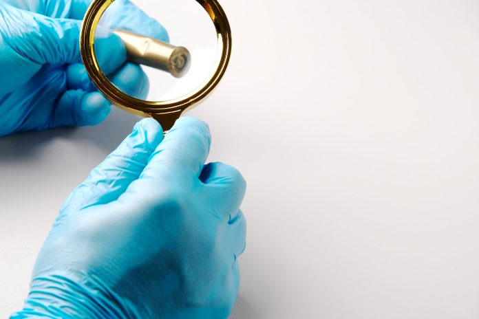 Forensic,Expert,Examines,A,Spent,Cartridge,Case,From,A,Firearm