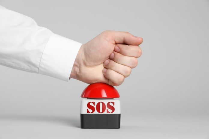 Man,Pressing,Red,Sos,Button,At,White,Background,,Closeup